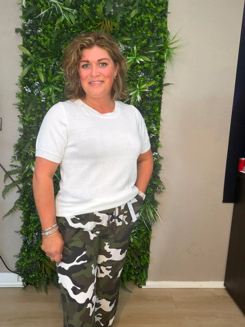 Army broek groen met wijde pijpen en camouflageprint, gecombineerd met een wit T-shirt