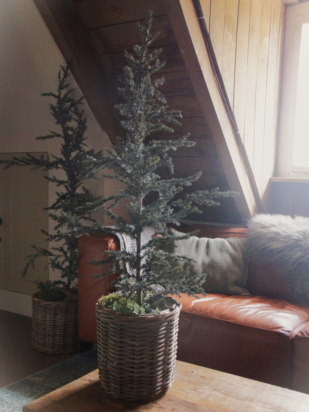 Sfeerbeeld BRYNXZ kunstbomen Tree Ceder Grey in twee maten, gestyled in rieten manden in een landelijke woonkamer